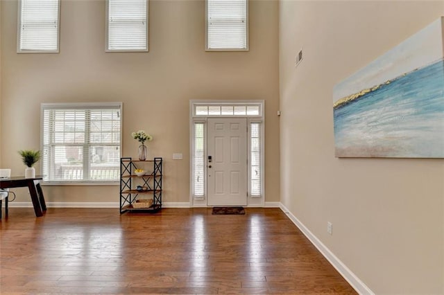 entrance foyer with a towering ceiling and hardwood / wood-style floors