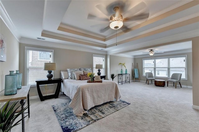 bedroom featuring crown molding, multiple windows, a tray ceiling, and light carpet