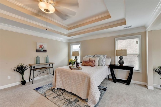 carpeted bedroom featuring crown molding and a raised ceiling