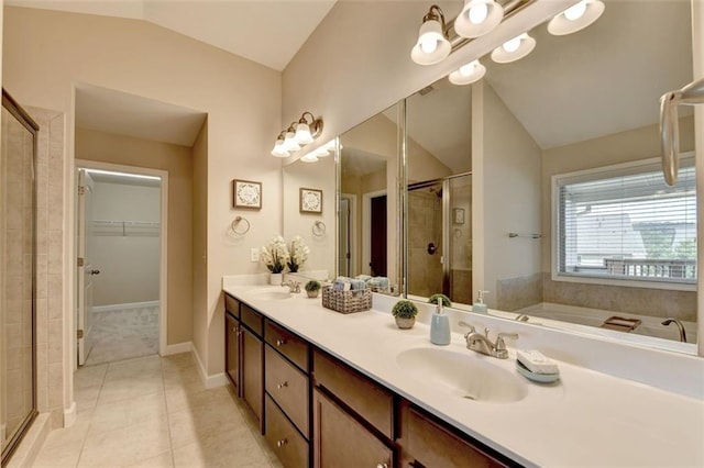 bathroom with tile patterned flooring, vaulted ceiling, separate shower and tub, and vanity