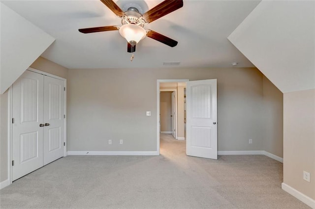 additional living space with ceiling fan and light colored carpet