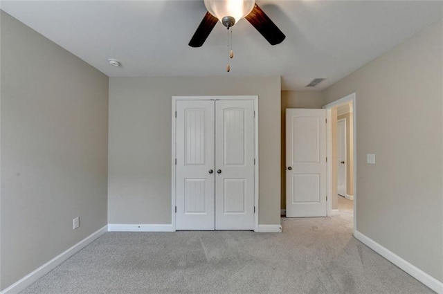 unfurnished bedroom with ceiling fan, light colored carpet, and a closet