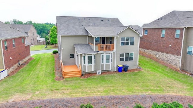 back of house featuring a lawn and a balcony