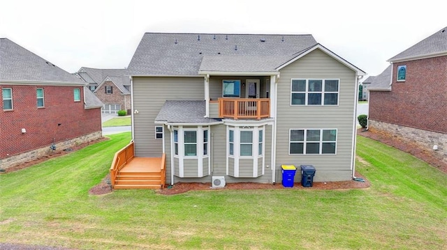 back of property featuring a balcony and a yard