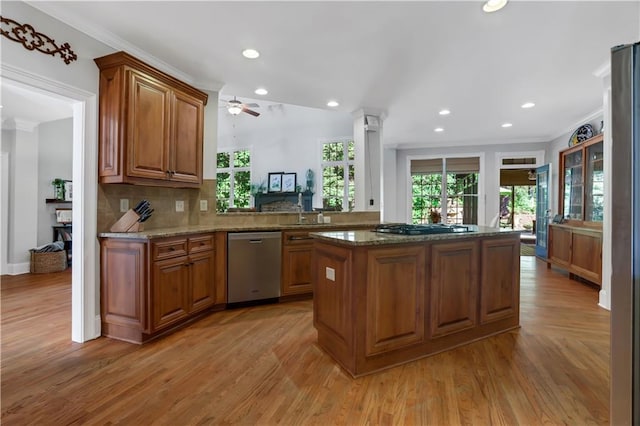 kitchen featuring stainless steel appliances, crown molding, stone counters, and kitchen peninsula