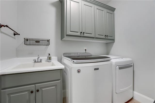 laundry room with cabinets, sink, and independent washer and dryer