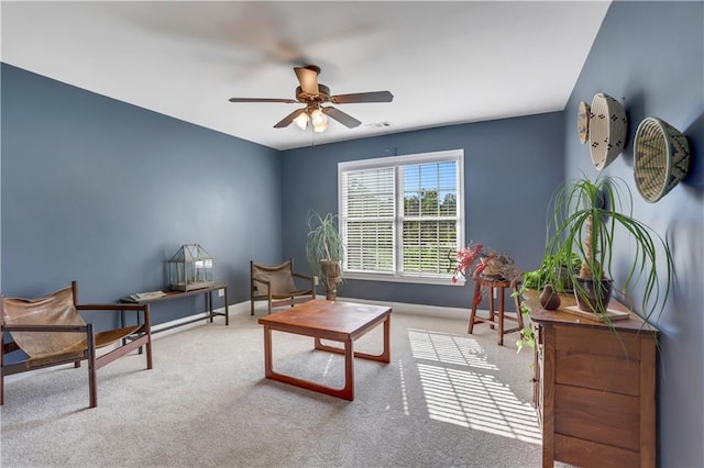 living area with ceiling fan and carpet