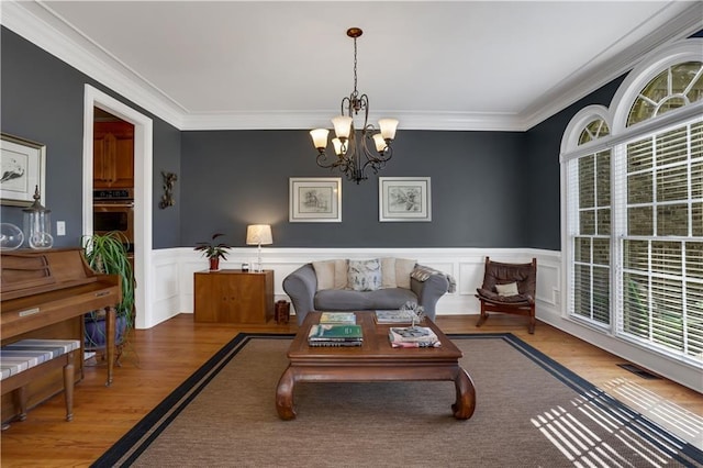 living room with hardwood / wood-style floors, a notable chandelier, and a wealth of natural light