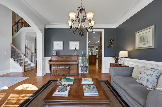 living room with a notable chandelier, hardwood / wood-style flooring, and ornamental molding