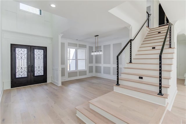 entrance foyer featuring french doors, light hardwood / wood-style flooring, and plenty of natural light