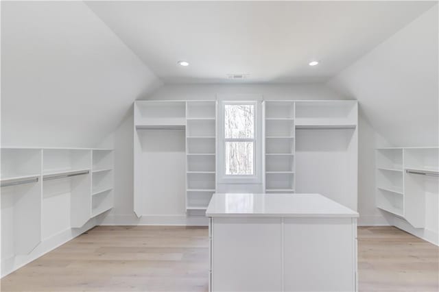 spacious closet featuring lofted ceiling and light hardwood / wood-style flooring