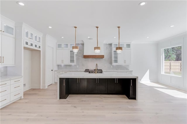 kitchen featuring a large island, light wood-type flooring, and hanging light fixtures