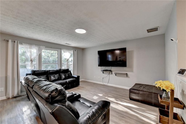 living room with wood-type flooring and a textured ceiling