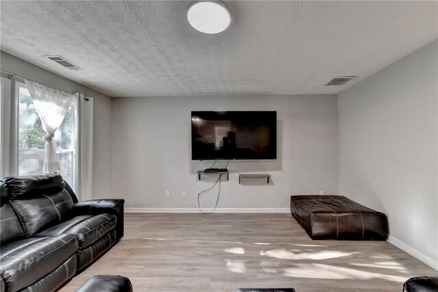 living room featuring a textured ceiling and light hardwood / wood-style floors