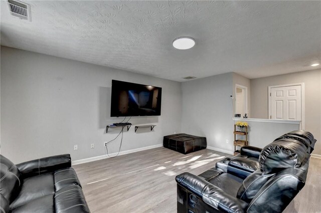 living room featuring a textured ceiling and hardwood / wood-style floors