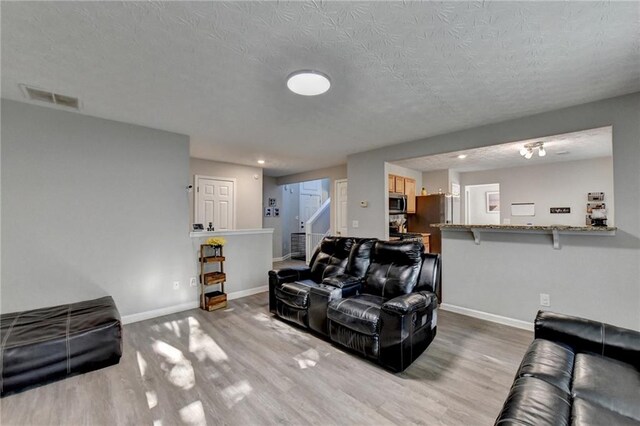 living room with a textured ceiling and hardwood / wood-style floors