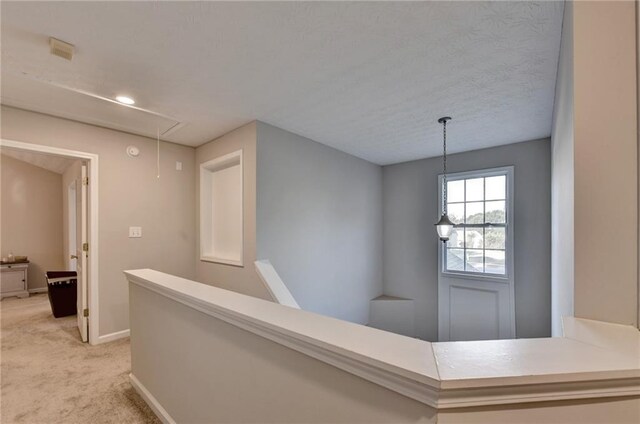 hallway featuring light colored carpet