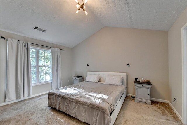 carpeted bedroom featuring a textured ceiling and lofted ceiling