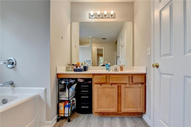 bathroom featuring vanity, a bathtub, and hardwood / wood-style flooring