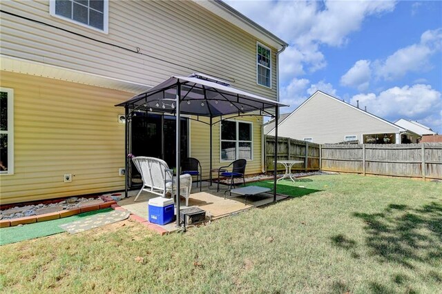 back of property with a yard and a patio