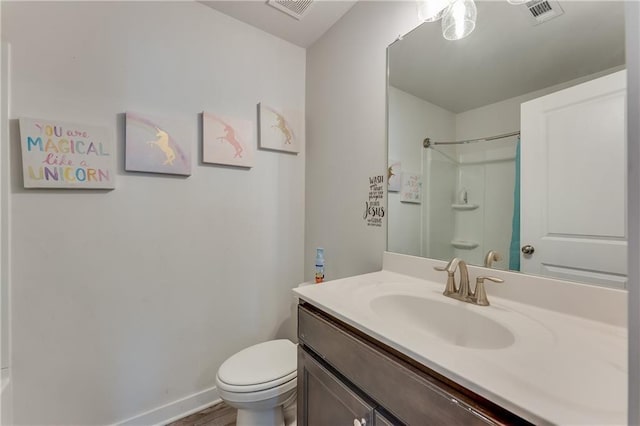 bathroom featuring walk in shower, vanity, toilet, and hardwood / wood-style floors