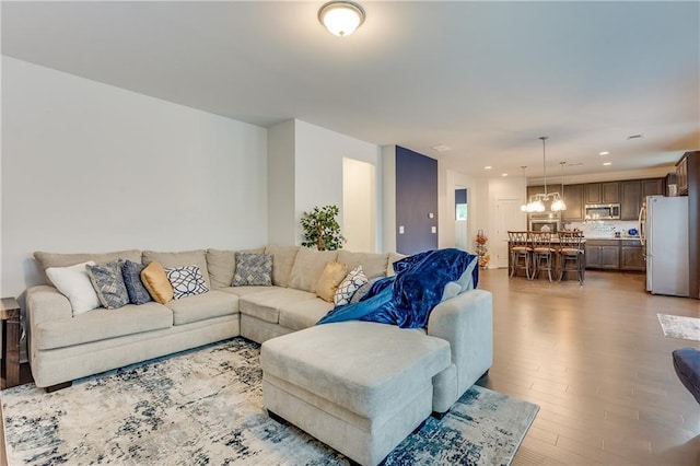 living room featuring a notable chandelier and light wood-type flooring