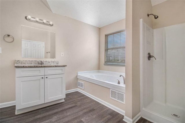 bathroom featuring visible vents, vanity, wood finished floors, and a shower stall