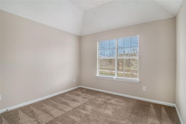 carpeted spare room with baseboards, lofted ceiling, and a textured ceiling