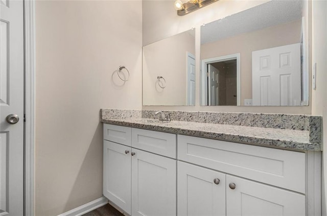 bathroom with vanity and baseboards