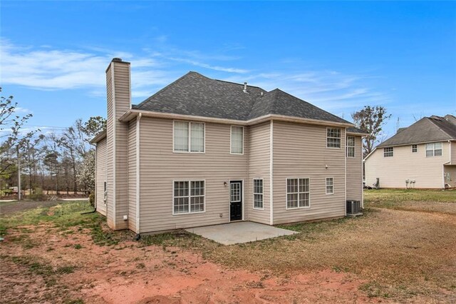 back of property featuring a patio area, a chimney, and central AC