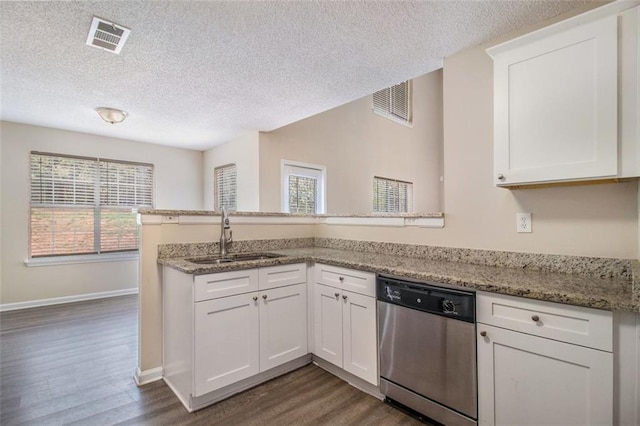 kitchen with a sink, visible vents, dishwasher, and a peninsula