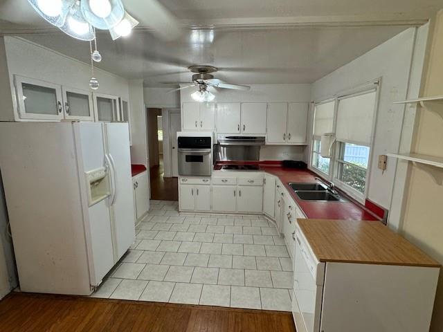 95 Jones St, Dahlonega, GA 30533 - kitchen with white fridge with ice dispenser, stainless steel oven, under cabinet range hood, ceiling fan, and white cabinetry