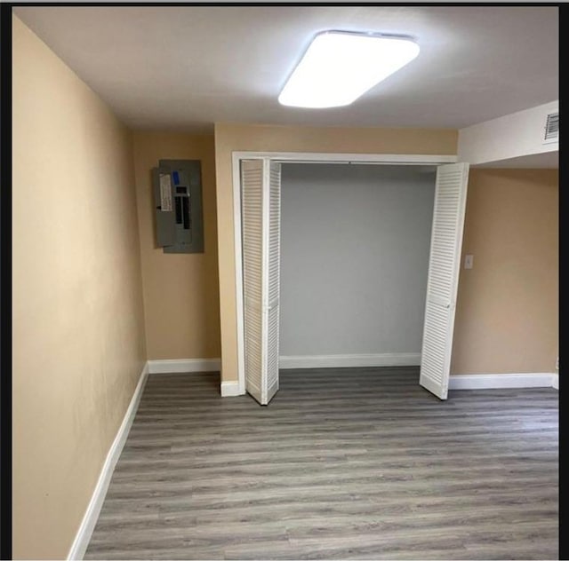 interior space with electric panel, hardwood / wood-style flooring, and a closet