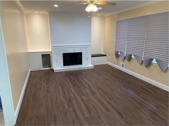 unfurnished living room featuring ceiling fan, a high end fireplace, dark hardwood / wood-style floors, and ornamental molding