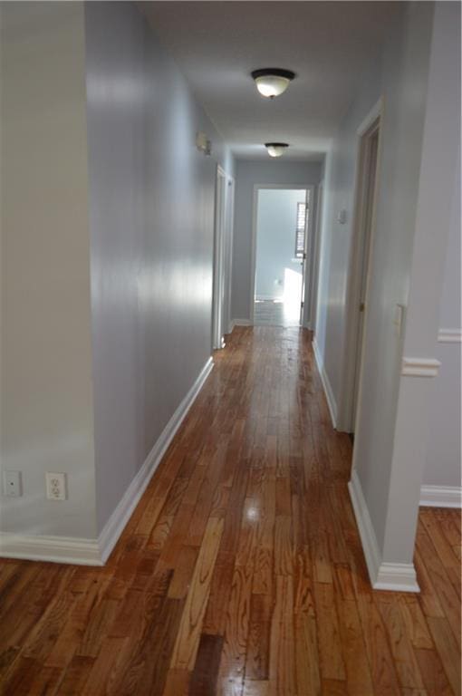 corridor with hardwood / wood-style flooring