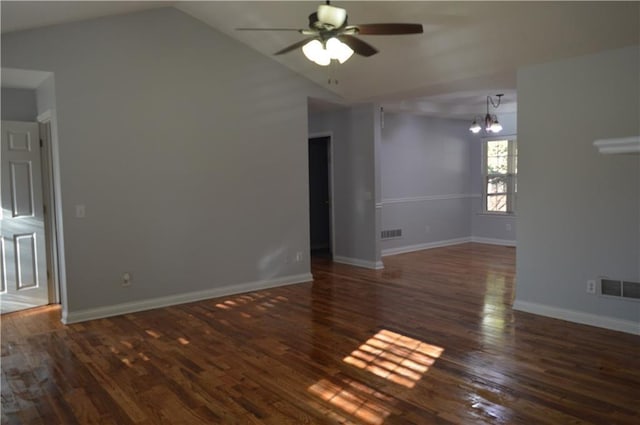 interior space featuring ceiling fan with notable chandelier, vaulted ceiling, and dark hardwood / wood-style floors