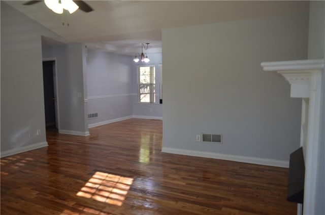 unfurnished living room with dark hardwood / wood-style flooring and ceiling fan with notable chandelier