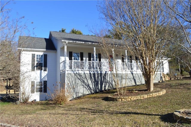 view of side of home with a yard and covered porch