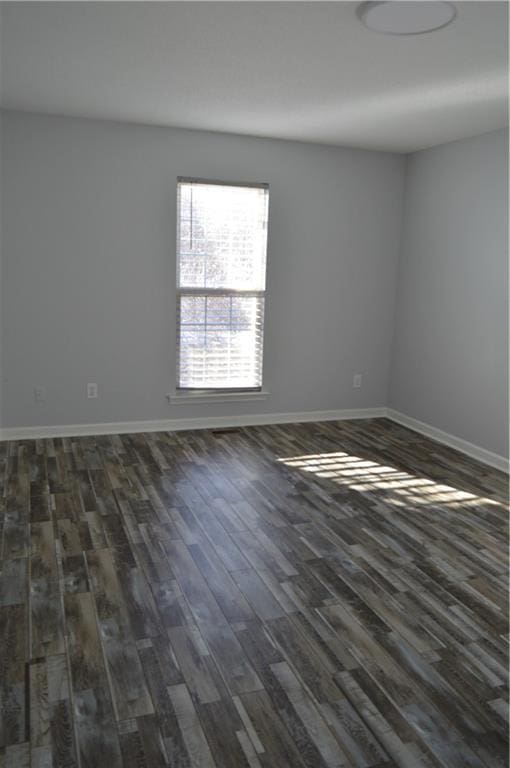 unfurnished room with dark hardwood / wood-style flooring