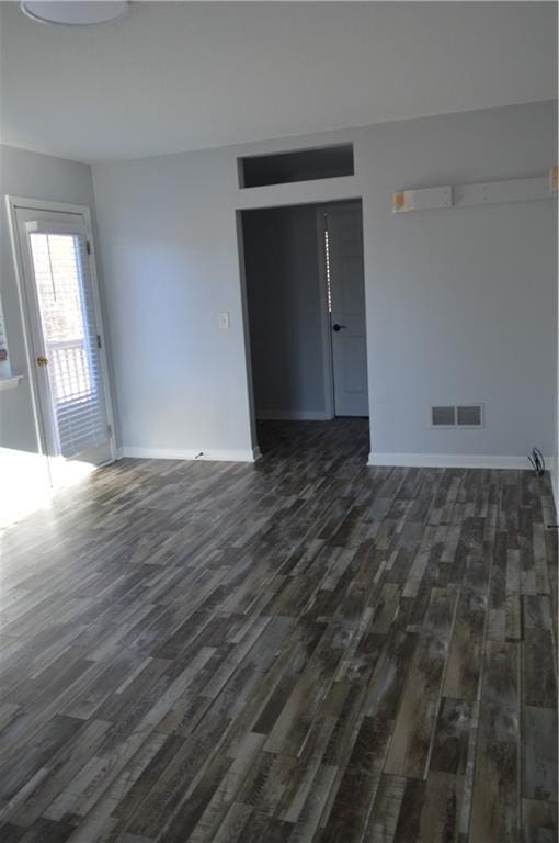 unfurnished room with dark wood-type flooring