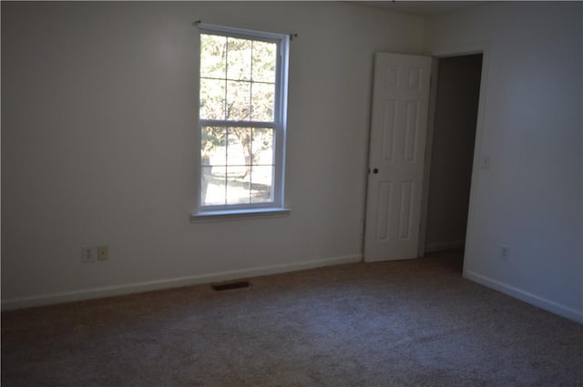 unfurnished room featuring a healthy amount of sunlight and carpet floors