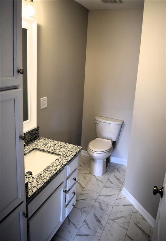 253 Woodland Way, Canton, GA 30114 - bathroom with toilet, vanity, marble finish floor, baseboards, and visible vents