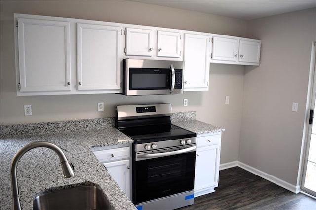 253 Woodland Way, Canton, GA 30114 - kitchen with white cabinetry, dark wood-style flooring, a sink, light stone countertops, and appliances with stainless steel finishes
