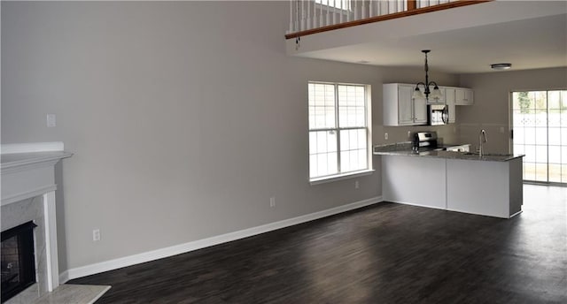 253 Woodland Way, Canton, GA 30114 - unfurnished living room featuring a sink, dark wood-style floors, baseboards, and a fireplace