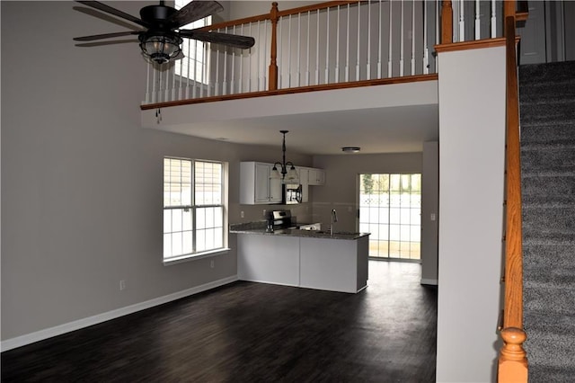 253 Woodland Way, Canton, GA 30114 - unfurnished living room featuring stairway, a ceiling fan, a high ceiling, dark wood finished floors, and baseboards