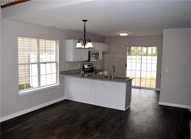 253 Woodland Way, Canton, GA 30114 - kitchen with dark wood-type flooring, baseboards, a sink, a peninsula, and appliances with stainless steel finishes