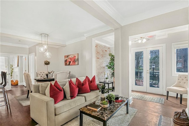 living room with wood finished floors, crown molding, and french doors