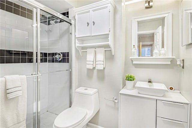 bathroom with a shower stall, toilet, and vanity