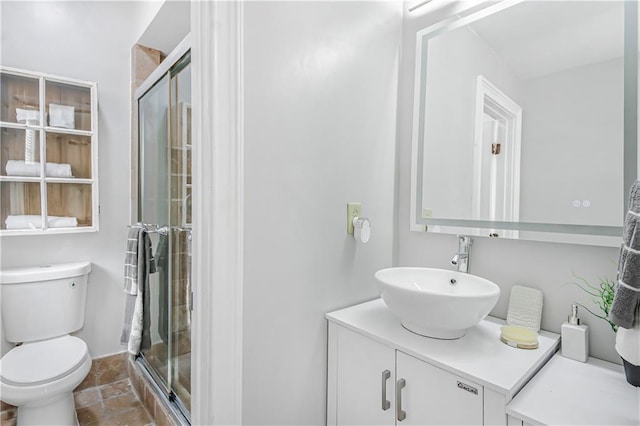 full bathroom featuring a stall shower, toilet, and vanity