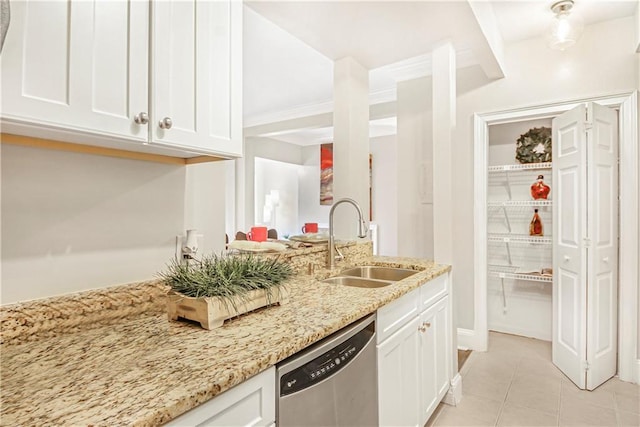 kitchen with stainless steel dishwasher, white cabinets, light stone counters, and a sink